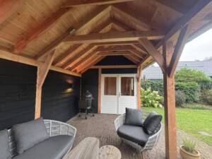 Houten overkapping of veranda voor beschut buiten zitten. Op maat gemaakt en passend bij woning en tuin.